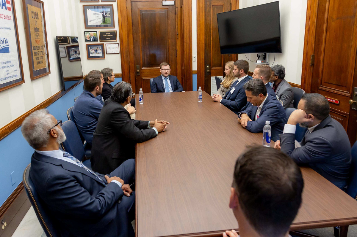 Healthcare leaders seated around a conference table during a summit roundtable
