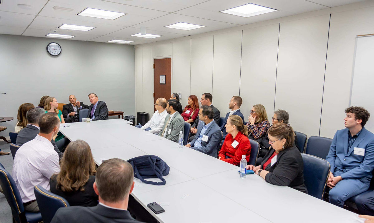 Summit attendees participating in a conference-room discussion