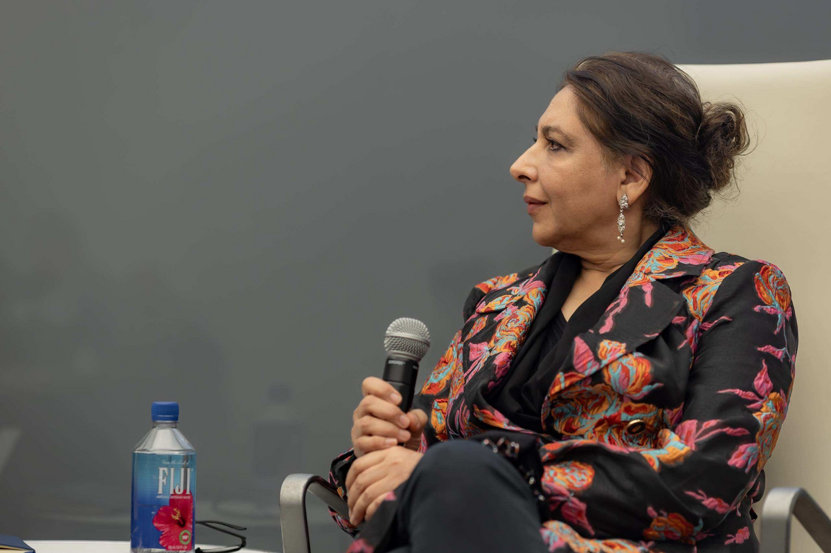 A panelist speaking with a handheld microphone
