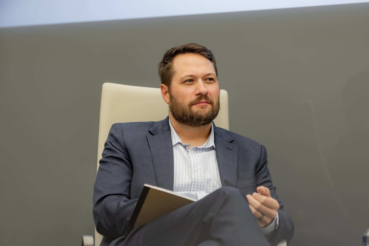 A panelist listening during a moderated conversation