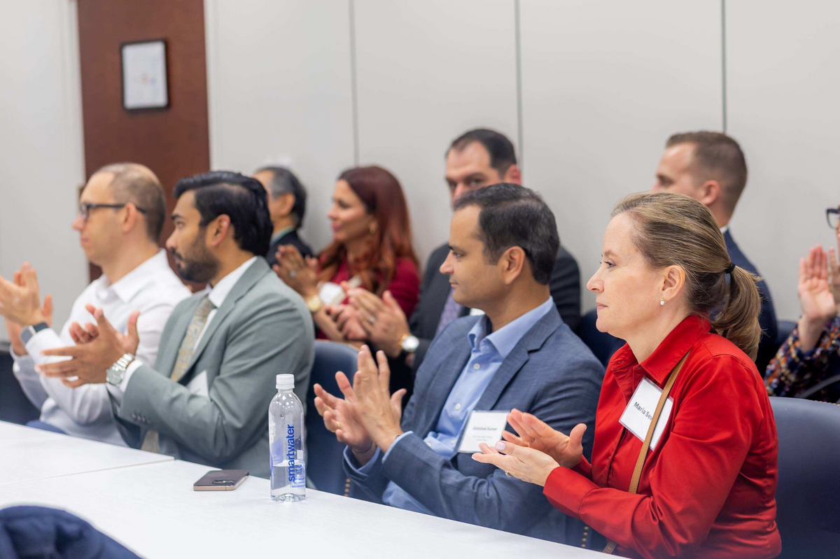 Summit participants applauding during a session